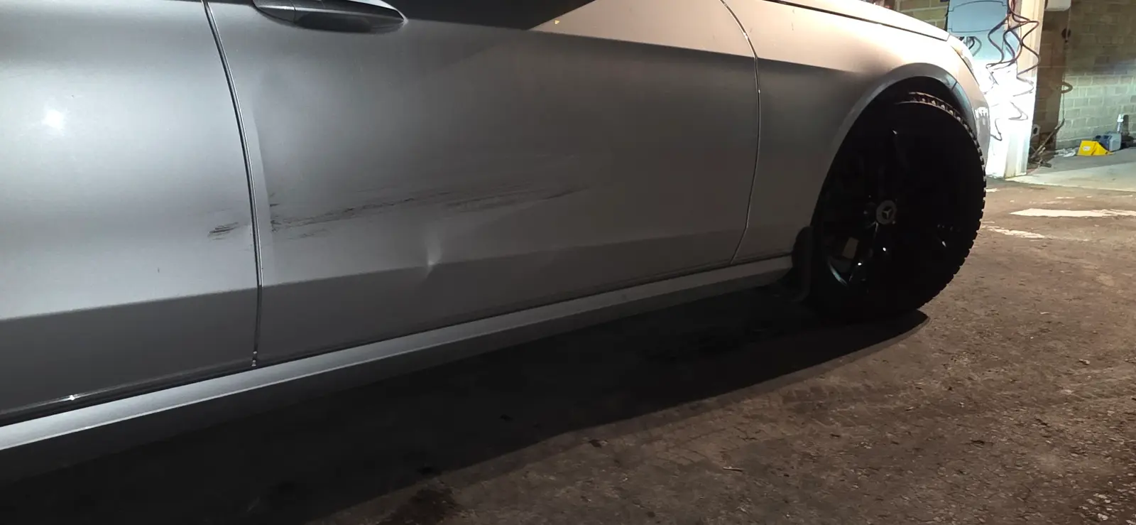 Scraped side panel on a silver Mercedes before repair