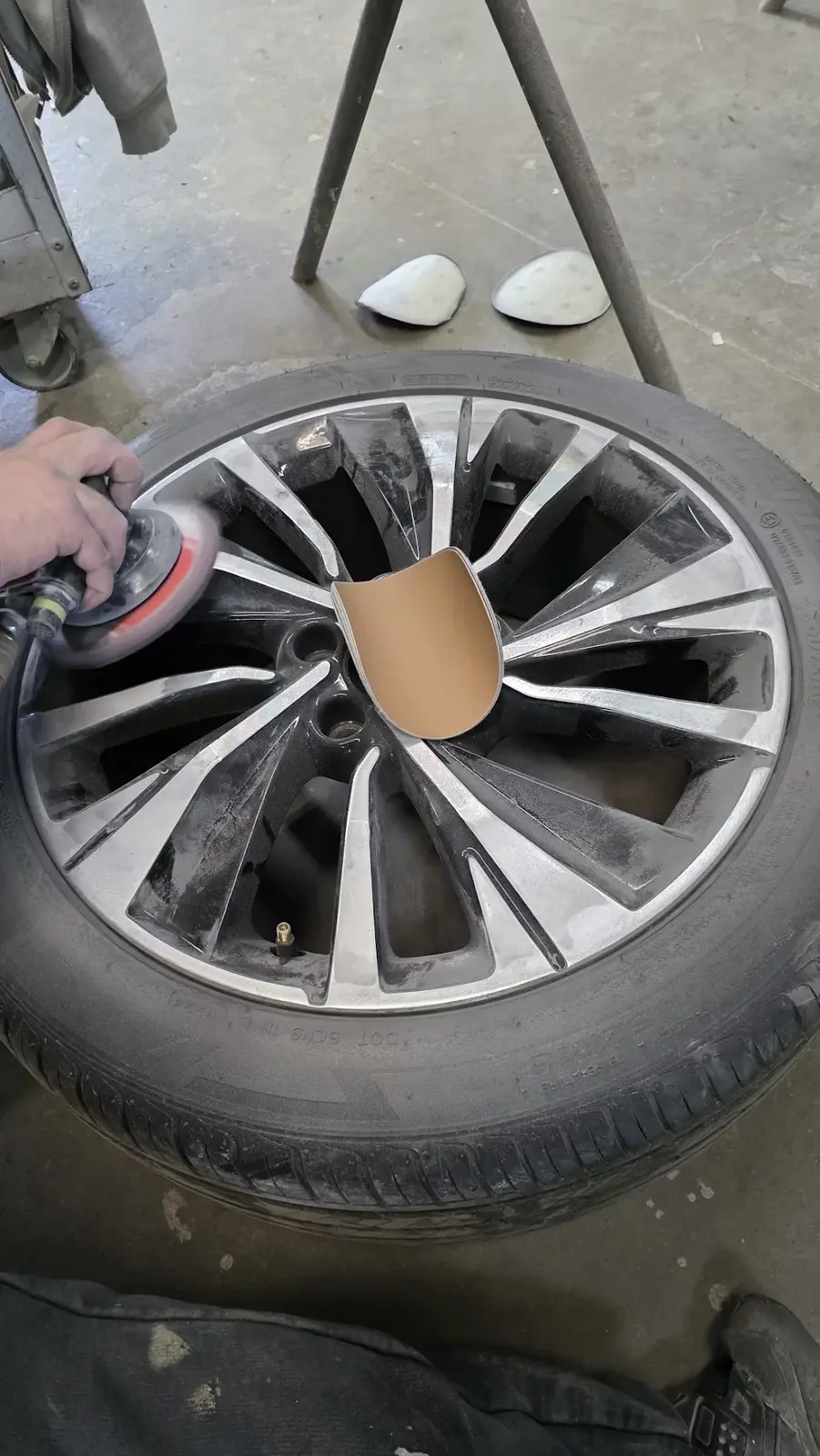 Scuffed alloy wheel being refinished